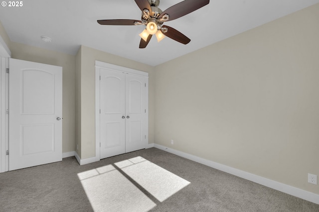 unfurnished bedroom featuring a ceiling fan, carpet, a closet, and baseboards