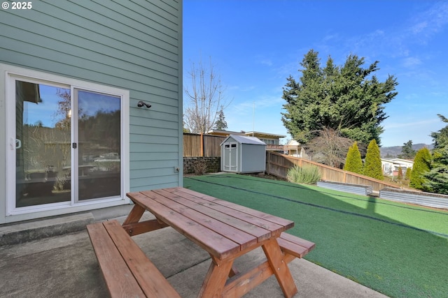 exterior space featuring an outbuilding, a storage unit, outdoor dining space, a patio area, and fence