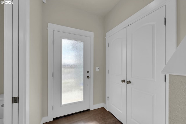 doorway to outside with dark wood finished floors and baseboards