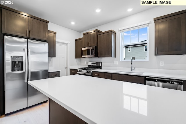 949 Legacy St, Eugene, OR 97402 - kitchen with appliances with stainless steel finishes, dark brown cabinetry, light countertops, recessed lighting, and light wood finished floors
