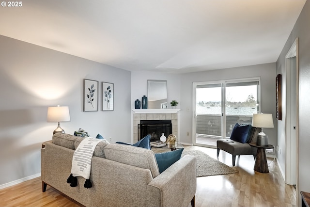 living room with light hardwood / wood-style flooring and a tile fireplace