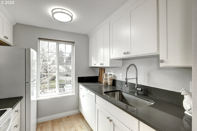 kitchen featuring white cabinetry, sink, white appliances, and a healthy amount of sunlight