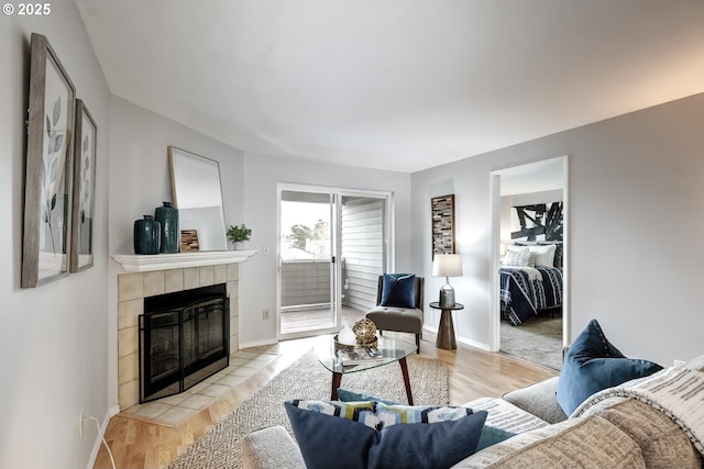 living room featuring a tile fireplace and light hardwood / wood-style flooring