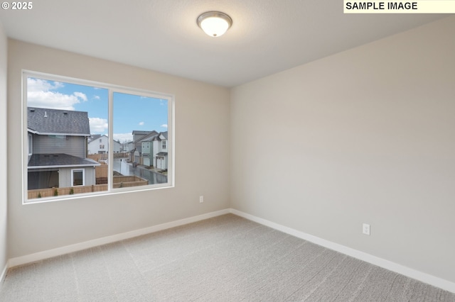 carpeted spare room with baseboards