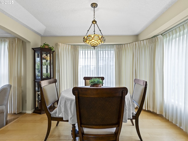 dining room featuring a textured ceiling and light wood finished floors