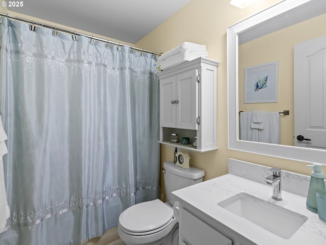 bathroom with curtained shower, vanity, and toilet