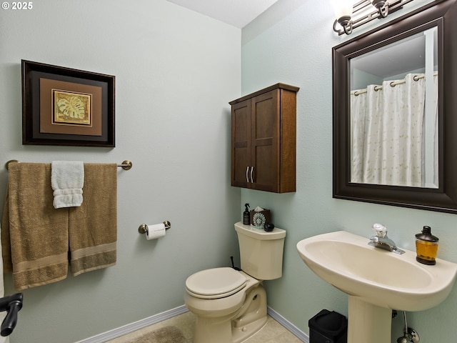 bathroom featuring a sink, toilet, and baseboards