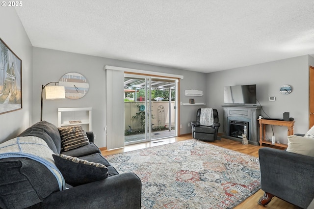 2112 SE 148th Pl, Portland, OR 97233 - living area featuring wood finished floors, a textured ceiling, and a fireplace