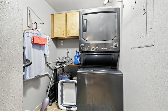 2112 SE 148th Pl, Portland, OR 97233 - laundry area with stacked washer and clothes dryer, cabinet space, and tile patterned flooring
