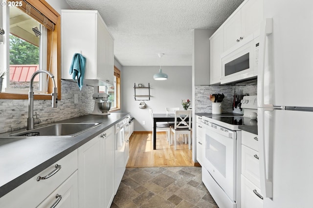 2112 SE 148th Pl, Portland, OR 97233 - kitchen featuring white appliances, decorative backsplash, dark countertops, white cabinets, and a textured ceiling