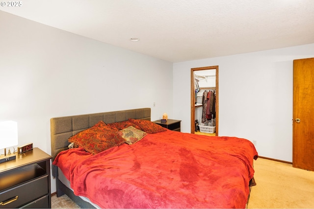 bedroom featuring light carpet, recessed lighting, baseboards, and a spacious closet
