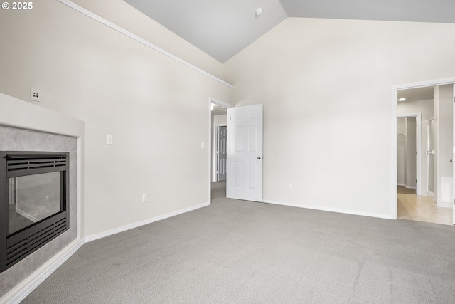 unfurnished living room with high vaulted ceiling, carpet, baseboards, and a tile fireplace