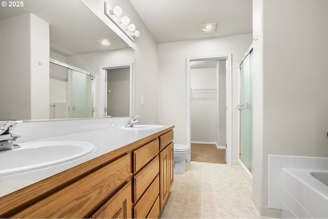 full bathroom featuring toilet, a stall shower, a spacious closet, and a sink