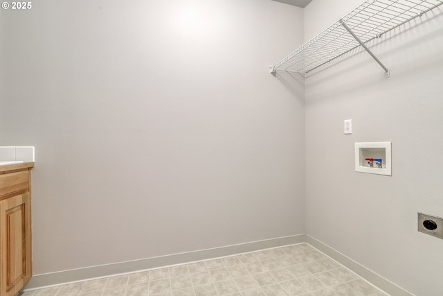 clothes washing area featuring hookup for a washing machine, hookup for an electric dryer, baseboards, cabinet space, and light floors