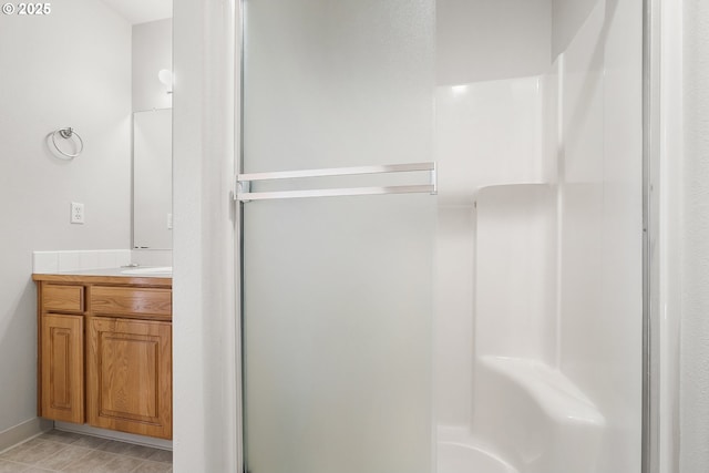 full bathroom featuring a stall shower, vanity, and tile patterned floors