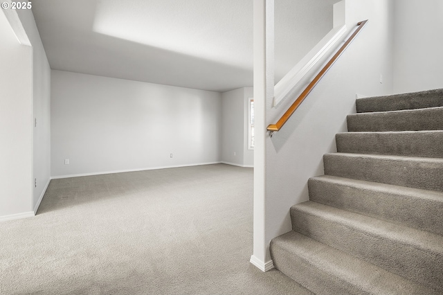 staircase featuring carpet and baseboards