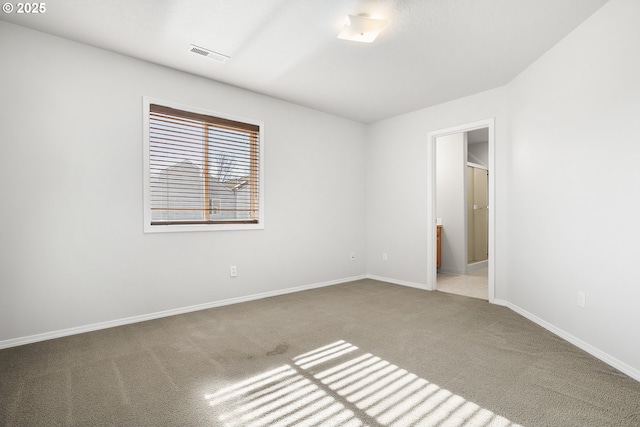 spare room featuring carpet floors, baseboards, and visible vents