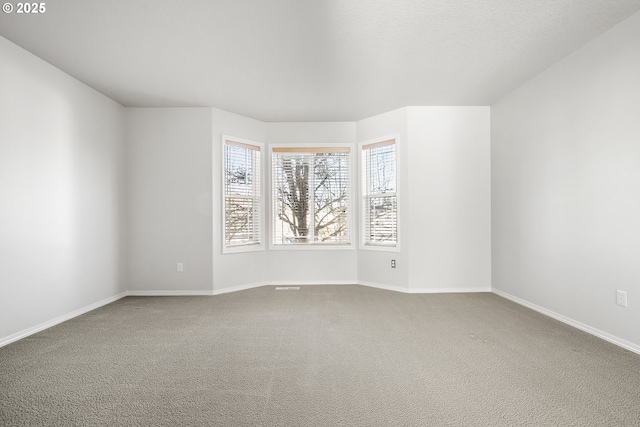 carpeted spare room with baseboards