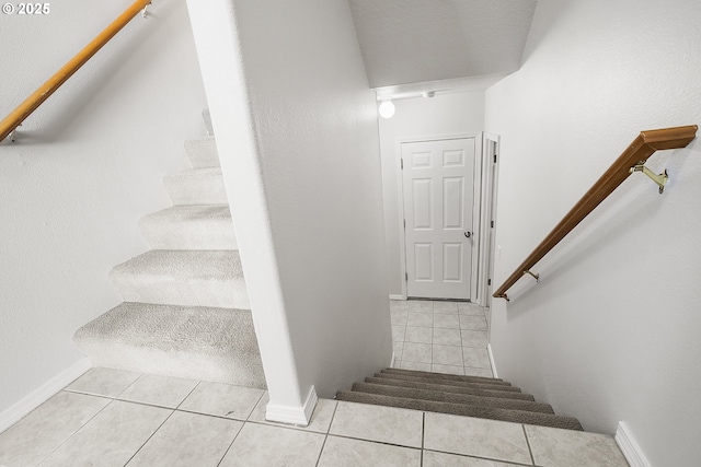 stairway featuring tile patterned flooring and baseboards