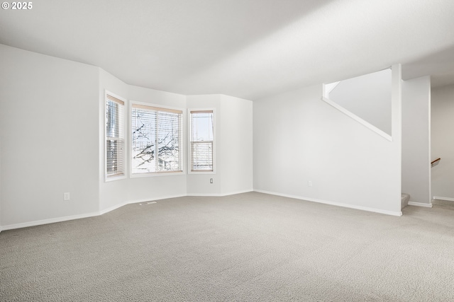 spare room featuring visible vents, stairs, baseboards, and carpet flooring