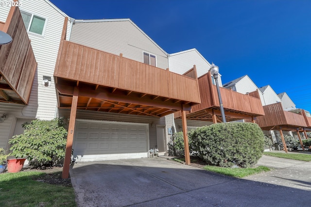 exterior space featuring a garage, driveway, and a balcony