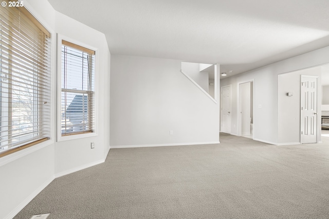 spare room featuring carpet flooring and baseboards