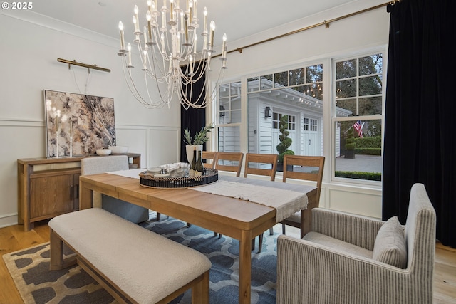 dining room featuring a notable chandelier, light hardwood / wood-style flooring, and ornamental molding