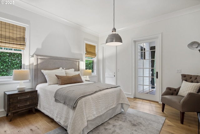 bedroom featuring crown molding, access to outside, and light hardwood / wood-style floors