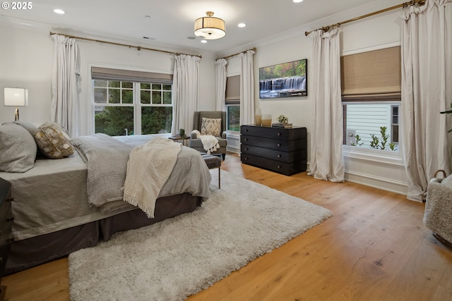 bedroom with crown molding, recessed lighting, and wood finished floors