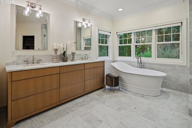 full bathroom featuring double vanity, a sink, a freestanding bath, and tile walls
