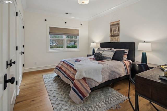 bedroom with crown molding and light hardwood / wood-style flooring