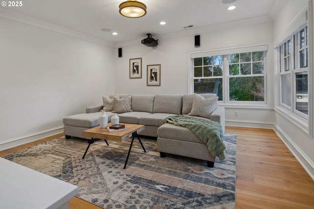 living room with crown molding, light wood-style floors, recessed lighting, baseboards, and visible vents