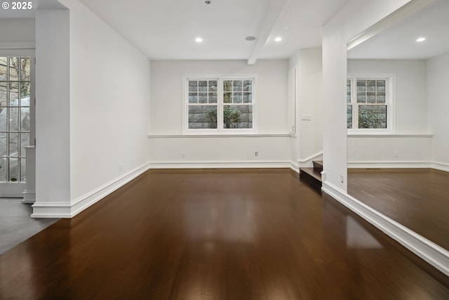 interior space with dark hardwood / wood-style flooring and beamed ceiling