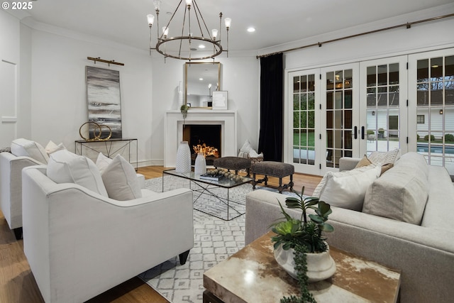 living room with french doors, ornamental molding, and light hardwood / wood-style floors