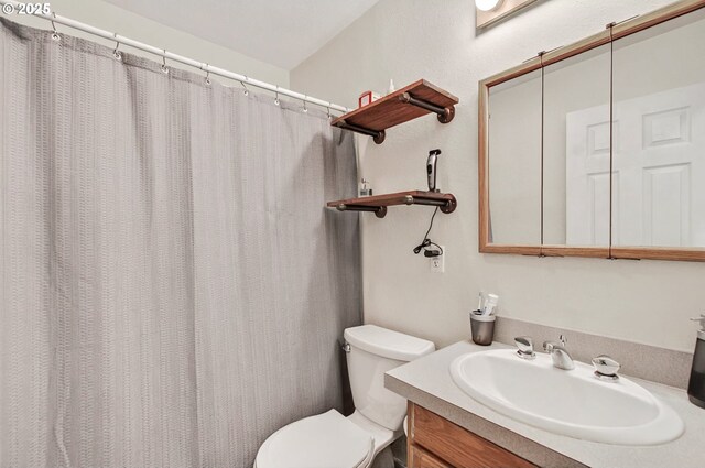 bathroom with toilet, vanity, and a shower with curtain