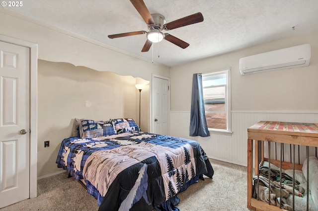 bedroom with a wall mounted AC, carpet, wainscoting, and ceiling fan