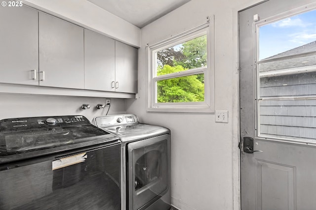 washroom with cabinet space, independent washer and dryer, and baseboards