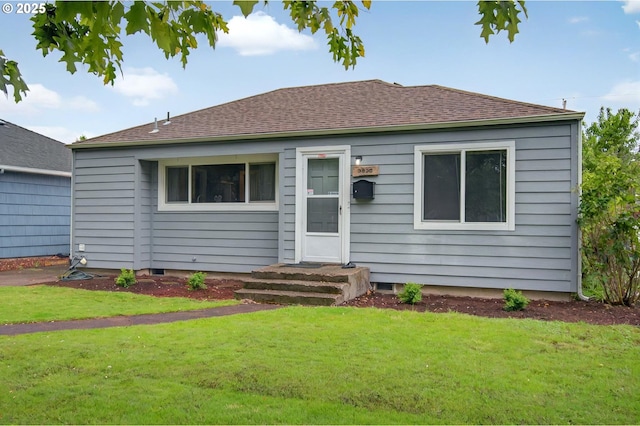 bungalow-style house with a front yard and a shingled roof