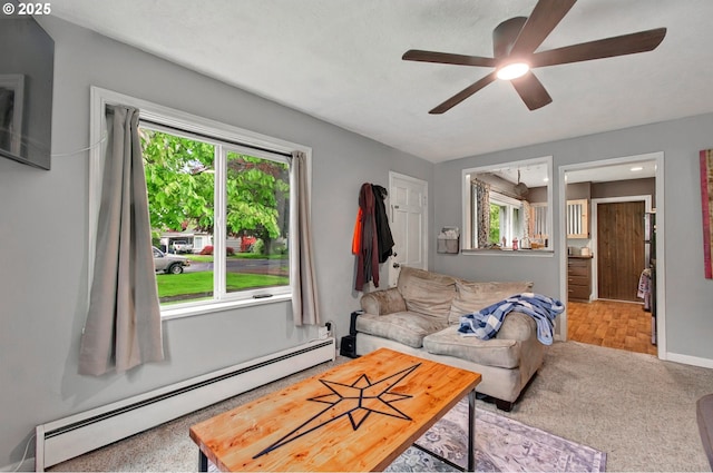 living area with a baseboard radiator, healthy amount of natural light, and ceiling fan