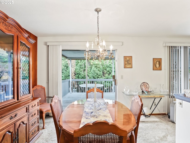 dining space with light colored carpet and a notable chandelier