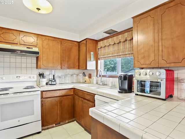 kitchen featuring decorative backsplash, a sink, white electric range oven, and under cabinet range hood