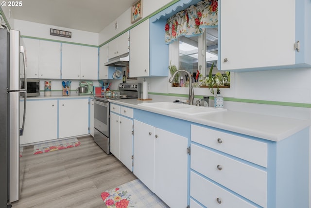 90431 Lewis Rd, Warrenton, OR 97146 - kitchen with appliances with stainless steel finishes, under cabinet range hood, a sink, and light countertops
