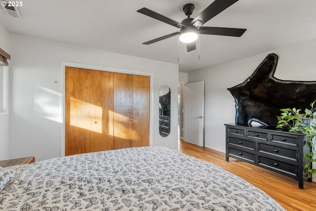 bedroom featuring ceiling fan, wood-type flooring, and a closet