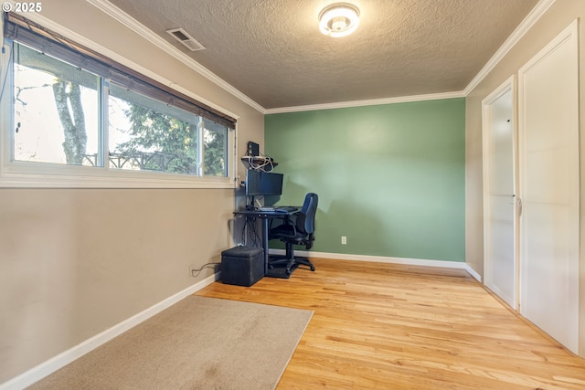 office area with crown molding, light hardwood / wood-style floors, and a textured ceiling