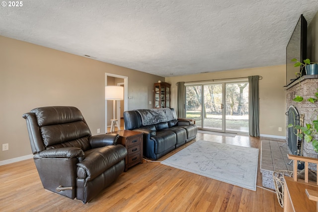 living room with a textured ceiling and light hardwood / wood-style flooring