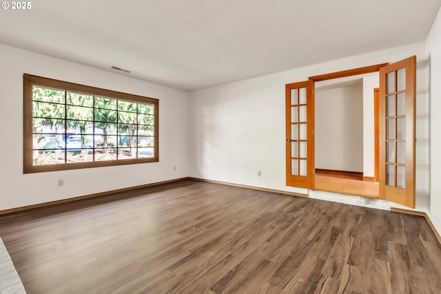 spare room with hardwood / wood-style flooring and french doors