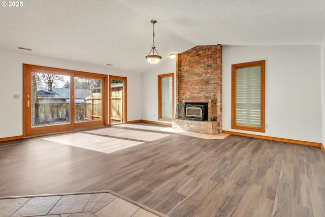 unfurnished living room with wood-type flooring, lofted ceiling, and a textured ceiling