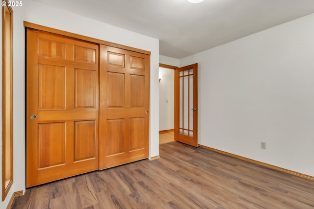 unfurnished bedroom featuring wood-type flooring and a closet