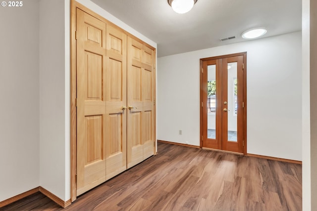 foyer with hardwood / wood-style floors and french doors