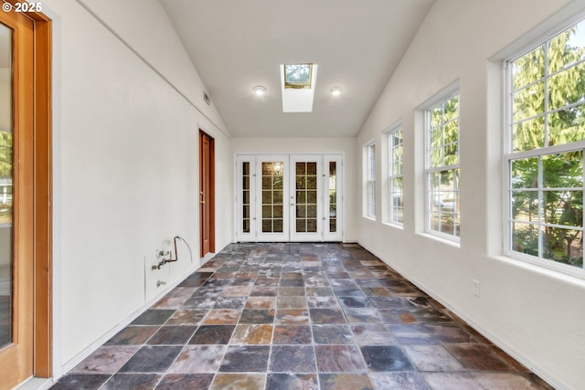 unfurnished sunroom with lofted ceiling with skylight